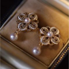 Pearl drop earrings with shiny pearls Carrying two dainty pearls, these pearl drop earrings are 18K gold plated and made of dainty crystals. Four pieces of crystal petals form a perfectly symmetrical flower and bloom with a 3-4mm shiny pearl in the center. The elegant pearl drop earrings are the ideal jewelry pieces to complement your wardrobe. With the sophisticated design and vintage style, the gold pearl drop earrings will make a statement of good taste and add a charming touch to your outfit Luxury Gold Pearl Earrings With Intricate Design, Ornate Gold Pearl Earrings Gift, Luxury Ornate Pearl Drop Earrings, Elegant Gold Flower-shaped Pearl Earrings, Luxury Flower-shaped Pearl Earrings, Vintage Diamond Earrings, Pearl Drop Earrings Gold, Pearl And Diamond Earrings, Crystal Drop Earrings