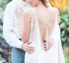 a bride and groom embracing each other in front of flowers