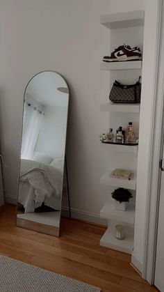 a mirror sitting on top of a wooden floor next to a shelf filled with shoes