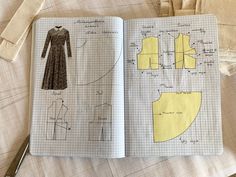 an open book with paper cut outs and sewing diagrams on it, including a dress pattern