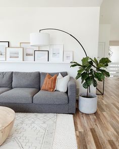 a living room filled with furniture and pictures on the wall next to a coffee table