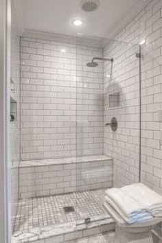 a white tiled bathroom with a walk in shower