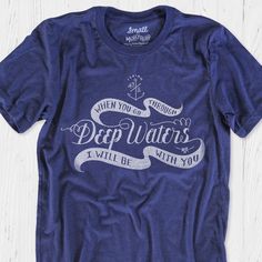 "This faith building religious tee shirt was hand lettered and illustrated in our studio--giving it a lovely vintage vibe. God is faithful to His Word! This encouraging graphic tee is perfect for remembering that you are not alone, God is with us when we face difficulty and trials. This nautical tee features an anchor, waves and \"When You Go Through Deep Waters, I Will Be With You\" from the Bible verse Isaiah 43:2.  ~ Professional screen printed with long lasting inks (no vinyl/iron-ons)  ~ Stays true to size, minimal to no shrinkage after washing  ~ Best unisex retail-fit tees in the industry, flattering on both men and women Bible Verse Inspiration  \"When you go through deep waters, I will be with you. When you go through rivers of difficulty, you will not drown. When you walk through Christian Shirt Designs, Camp T Shirt, Water Shirt, Isaiah 43 2, Church Branding, Christian Shirts Designs, Bible Verses For Women, Isaiah 43, Faith Clothing