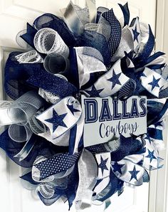 a wreath with the word, dallas cowboys on it is hanging on a front door