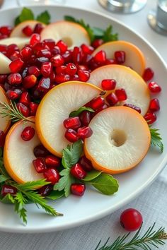 a white plate topped with sliced apples and pomegranates