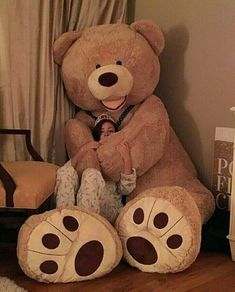 a large teddy bear sitting on top of a wooden floor