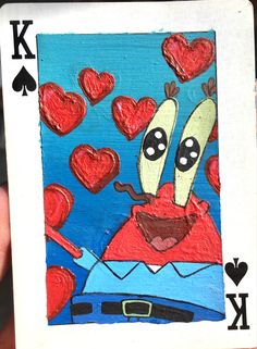 a hand holding up a playing card with hearts in the sky and two bananas on it