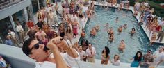 a crowd of people standing around a swimming pool