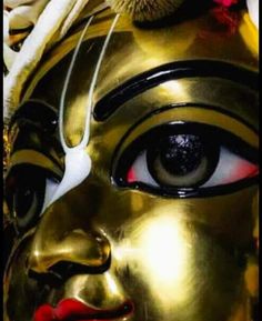 a close up of a gold mask with red eyes