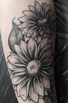 a black and white flower tattoo on the leg