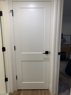 a white door with black handles in a room