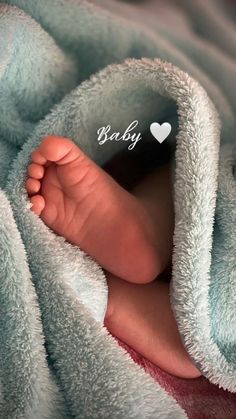 a baby's feet are covered in a blanket