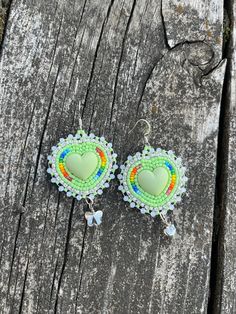 Beaded green heart shaped earrings edged with crystal banding, backed with faux leather on hooks. A grey butterfly charm was also attached to the bottom on the earrings. Cowboy Beaded Earrings, Dangling Beaded Earrings, Green Heart-shaped Bohemian Earrings, Green Dangle Heart Charm Earrings, Adjustable Heart-shaped Beaded Earrings, Heart Beaded Earrings, Flower Applique Patterns, Beading Board, Grey Butterfly