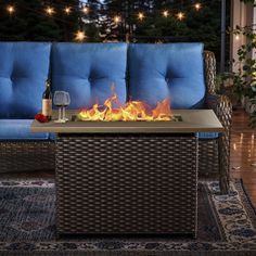 a fire pit sitting on top of a blue couch next to a glass of wine