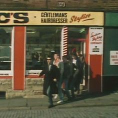 people walking in front of a hairdresser shop