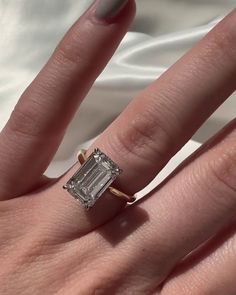 a woman's hand with a ring on it and a diamond in the middle