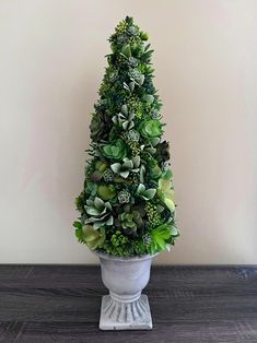 a potted plant with succulents in it on a wooden table next to a wall