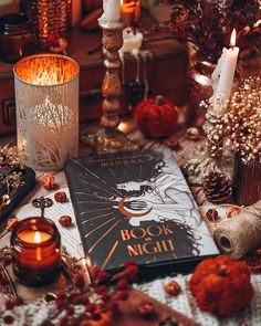 a book sitting on top of a table next to candles and other things in front of it