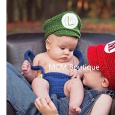 two babies are wearing matching hats while sitting on a couch