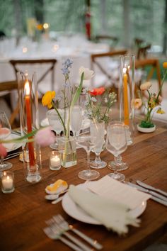 a wooden table topped with lots of plates and glasses