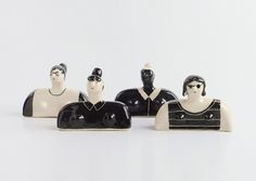 three black and white ceramic figurines sitting next to each other