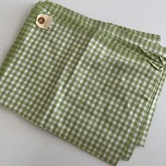 a green and white checkered cloth with a button on it