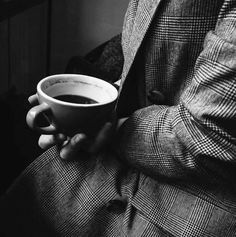 a man holding a cup of coffee in his hands