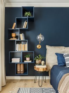 a bedroom with blue walls and bookshelves on the wall