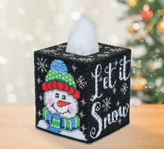 a christmas themed tissue box with a snowman on it and the words let it snow