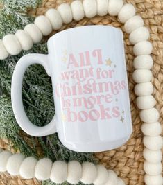 a white coffee mug sitting on top of a wicker basket next to christmas decorations