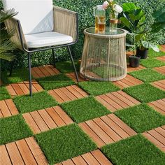 a chair and table sitting on top of a grass covered ground with potted plants