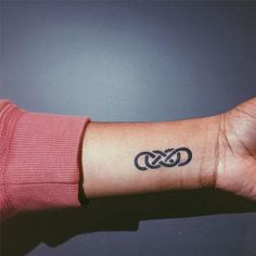 a person's arm with a tattoo that has two intertwined links on it