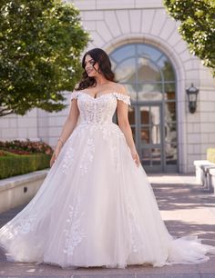 a woman in a wedding dress is walking down the street with her hand on her hip