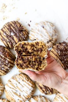 a person holding up a chocolate chip cookie