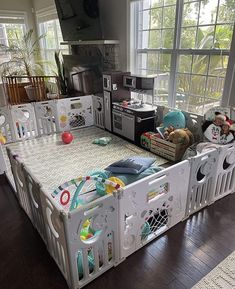 a child's playpen in the middle of a room with lots of toys