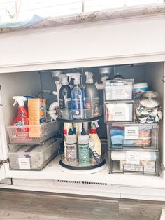 the inside of a kitchen cabinet filled with cleaning products and other household care items in containers