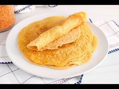 three pancakes on a white plate next to a jar of peanut butter