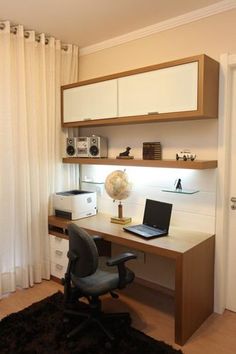 a desk with a laptop on top of it in front of a white curtained window