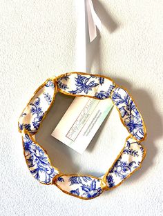 a blue and white plate with a business card in it on the wall next to a toothbrush holder