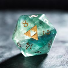 a green and gold dice sitting on top of a table