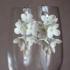 Elegant White Floral Dangle Earrings, Handmade Polymer Clay Flower Earrings, Lightweight Spring Jewelry Description: Enhance your style with these exquisite handmade white floral dangle earrings. Crafted from high-quality polymer clay, each flower petal is delicately shaped to mimic the natural beauty of blossoming flowers. These earrings are lightweight, making them perfect for everyday wear or special occasions. The soft white color adds a touch of elegance, making them a versatile accessory that complements any outfit. Whether you're looking for a unique gift or a stunning piece of jewelry for yourself, these floral earrings are an excellent choice. Ideal for spring and summer fashion, weddings, or as a thoughtful gift for someone special. Details: Material: Polymer Clay, Metal Alloy (H White Dangle Flower Earrings With 3d Flowers, White 3d Flower Dangle Earrings, White Dangle Earrings With 3d Flowers, White Dangle Flower Earrings, White Dangle Earrings With Flower Decoration, Delicate White Flower Earrings With Ear Wire, Handmade White Flower Drop Earrings, White Handmade Flower Drop Earrings, White Dangle Earrings With Flower Charm