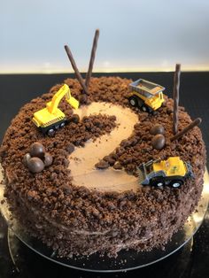 a chocolate cake with construction vehicles on top