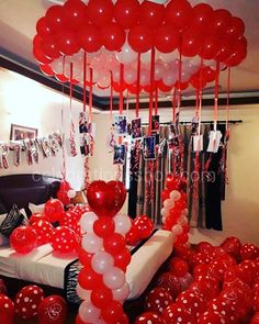 a room filled with red and white balloons