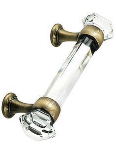 a glass and brass colored handle on a white background