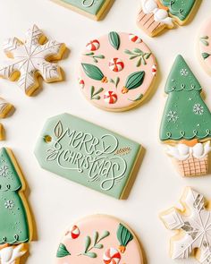 decorated christmas cookies are arranged on a white surface with the words merry christmas written in cursive