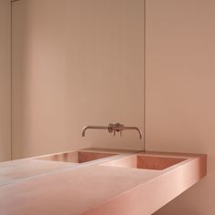 a bathroom sink with two faucets and a mirror in the wall behind it