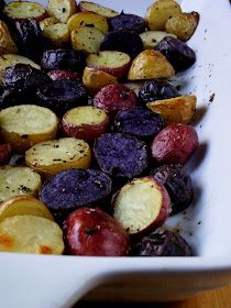 potatoes and plums in a white casserole dish with seasoning on top