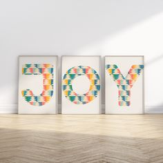 three art prints with the word yo spelled in colorful geometric shapes on a wood floor