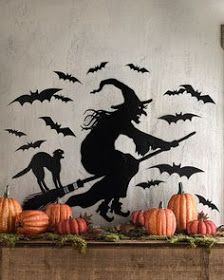 a halloween scene with pumpkins, bats and a silhouette of a witch on a broom