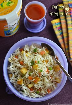 a bowl filled with rice and veggies next to a container of sauce